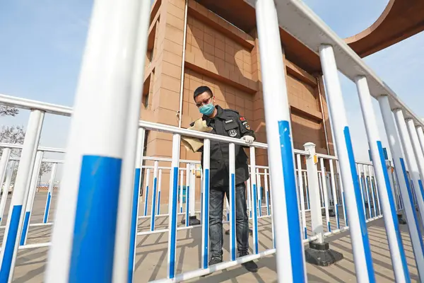 LUANNAN COUNTY, Hebei Eyaleti, Çin - 9 Nisan 2020: bir adam çevreyi temizlemek için metal korkulukları siler, koronavirüs zatürreesini önler.