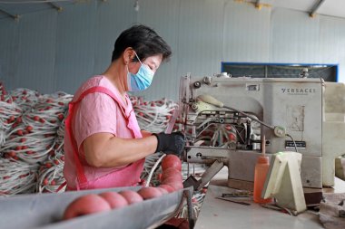 LUANNAN COUNTY, Hebei Eyaleti, Çin - 20 Ağustos 2020: işçiler fabrikalarda ağ şamandıraları dikmek için dikiş makineleri kullanıyorlar