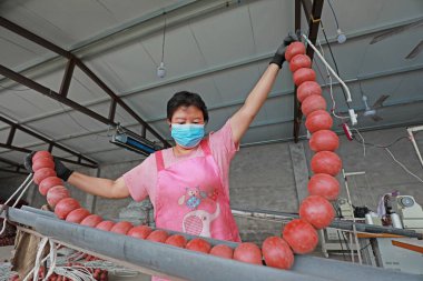 LUANNAN COUNTY, Hebei Eyaleti, Çin - 20 Ağustos 2020: işçiler fabrikalarda ağ şamandıraları dikmek için dikiş makineleri kullanıyorlar