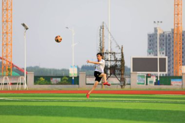 LUANNAN COUNTY, Hebei Eyaleti, Çin - 23 Ağustos 2020: Gençler çimlerde futbol oynuyorlar