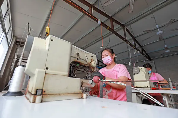 LUANNAN COUNTY, Hebei Eyaleti, Çin - 20 Ağustos 2020: işçiler fabrikalarda ağ şamandıraları dikmek için dikiş makineleri kullanıyorlar