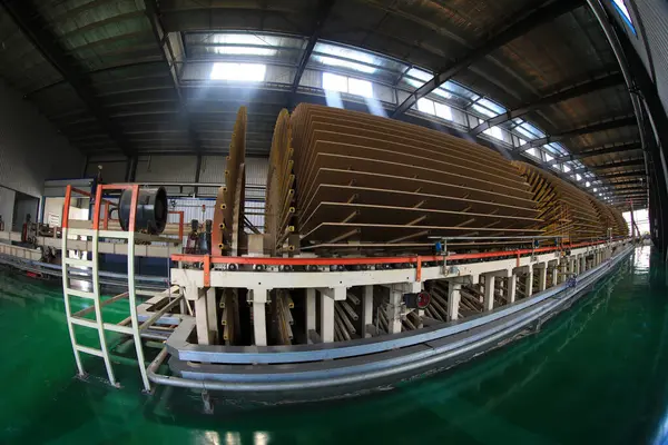  İşçiler üretim hattında plaka üretmek için makineleri kontrol ediyorlar