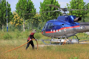 LUANNAN COUNTY, Hebei Eyaleti, Çin - 7 Eylül 2020: İşçiler tarım helikopterine yakıt ikmali yapıyor ve tedavi ediyorlar