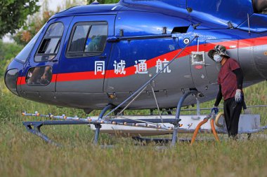 LUANNAN COUNTY, Hebei Eyaleti, Çin - 7 Eylül 2020: İşçiler tarım helikopterine yakıt ikmali yapıyor ve tedavi ediyorlar