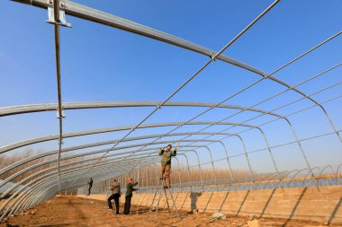 LUANNAN COUNTY, Çin - 2 Aralık 2020: işçiler eliptik galvanize boru iskelet seralar inşa çiftlikler, LUANNAN COUNTY, Hebei Eyaleti, Çin