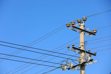 Mavi gökyüzü arka planında güç iletim ekipmanları
