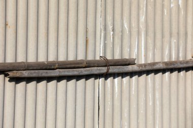 Asbest kiremitleri ve tahta direkler birbirine bağlıdır.