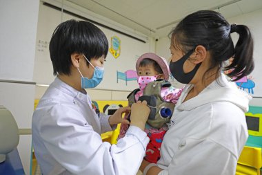 LUANNAN COUNTY, Hebei Eyaleti, Çin - 11 Mayıs 2020: Bir kadın hemşire bir çocuk hasta için buğulanmaya hazırlanıyordu.