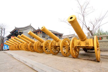 LUAN COUNTY - NOVEMBER 23: Copper artillery and antique buildings in Luanzhou city, on november 23, 2014, Luan County, Hebei Province, China clipart