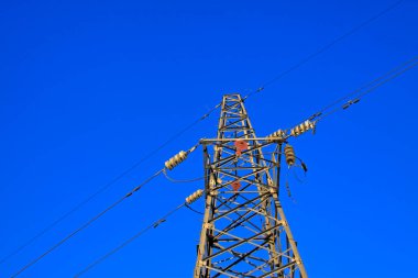 Mavi gökyüzünün altındaki elektrik kulesi, fotoğrafa yakın çekim.