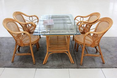 Bambu sandalye ve cam çay masası, fotoğrafa yakın çekim.