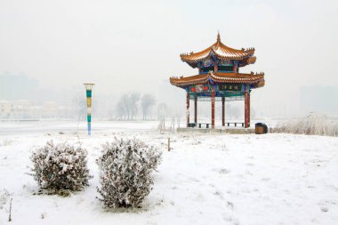 Bir parkta karla kaplı manzara, fotoğrafa yakın çekim.