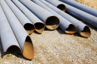 Çelik boru yere yığılmış, fotoğrafa yakın çekim. 