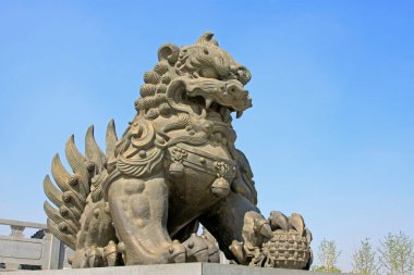 Bakır aslan heykeli mavi gökyüzünün altında bir parkta, Çin 'de