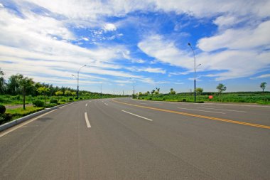 Mavi gökyüzünün altındaki karayolu beyaz bulut