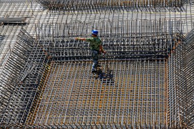 İnşaat işçileri inşaat alanında güçlendirilmiş beton çerçeve yapıyorlar.