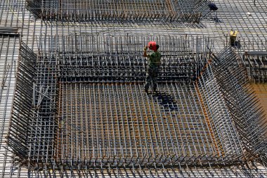 İnşaat işçileri inşaat alanında güçlendirilmiş beton çerçeve yapıyorlar.