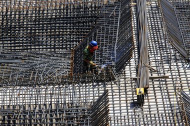 İnşaat işçileri inşaat alanında güçlendirilmiş beton çerçeve yapıyorlar.