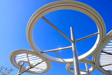 Mavi gökyüzü altında paslanmaz çelik çember mimarisi