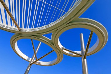 Mavi gökyüzü altında paslanmaz çelik çember mimarisi