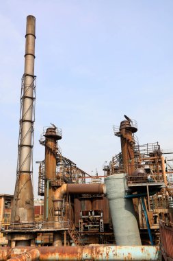 Fabrikadaki boru hattı ve baca, fotoğrafa yakın çekim.