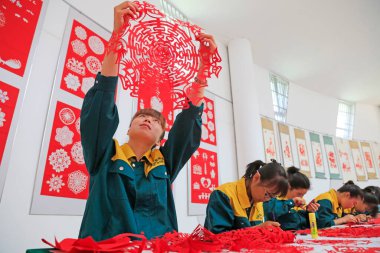 Luannan İlçesi - 13 Mayıs 2016 'da, Çin' in Hebei Eyaleti, Luannan İlçesi 'nde kağıt kesim çalışmaları izleyen bir kız