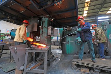 LUANNAN COUNTY, Çin - 22 Nisan 2021: işçiler Kuzey Çin 'deki bir kürek fabrikasında çelik kürek üretim hattı üzerinde sıkı çalışıyorlar