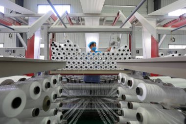 LUANNAN COUNTY, Çin - 17 Haziran 2021: İşçiler Kuzey Çin 'deki plastik dokuma atölyesinde sıkı çalışıyorlar
