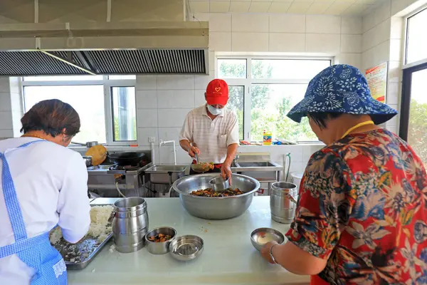 stock image LUANNAN COUNTY, China - July 8, 2021: canteen staff serving rice and vegetables in rural China