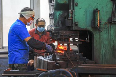 LUANNAN COUNTY, Çin - 24 Eylül 2021: işçiler yoğun bir şekilde Kuzey Çin 'deki bir donanım üretim fabrikasında üretim bandı üzerinde çalışıyorlar.