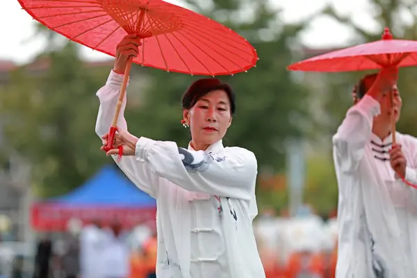 stock image LUANNAN COUNTY, China - October 10, 2021: people perform Tai Chi umbrellas in the park, North China