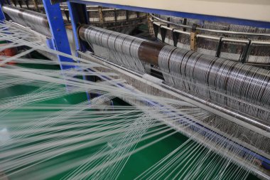 Plastik örgü üretim hattının mekanik ekipmanları bir fabrikada çalışıyor.