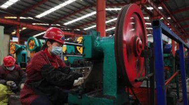 LUANNAN COUNTY, Çin - 22 Nisan 2021: işçiler Kuzey Çin 'deki bir kürek fabrikasında çelik kürek üretim hattı üzerinde sıkı çalışıyorlar