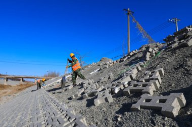 Tangshan, Çin - 24 Aralık 2021: İşçiler Kuzey Çin 'deki bir su koruma projesi sahasında nehir yamaç koruması inşa ediyorlar