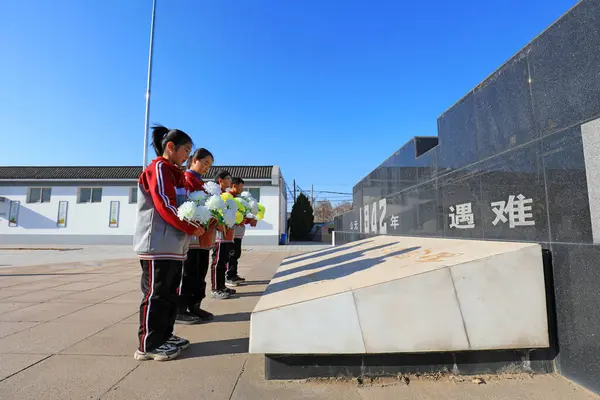 stock image LUANNAN COUNTY, China - December 13, 2021: The students presented flowers to the monument, North China