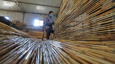 LUANNAN COUNTY, Çin - 21 Haziran 2021: işçiler Kuzey Çin 'deki bir fabrikada sazlık perdeleri işlemek için makineler kullanıyorlar