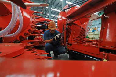 LUANNAN COUNTY, Çin - 27 Temmuz 2021: işçiler Kuzey Çin 'de bir üretim atölyesinde tarım makineleri montajı yapıyorlar