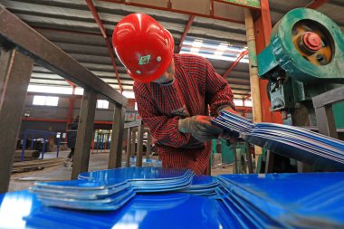 LUANNAN COUNTY, Çin - 22 Nisan 2021: işçiler Kuzey Çin 'deki bir kürek fabrikasında çelik kürek üretim hattı üzerinde sıkı çalışıyorlar