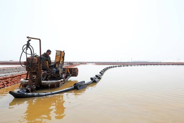 LUANNAN COUNTY, Çin - 27 Nisan 2021: işçiler, Kuzey Çin 'deki bir tuz tarlasında çalışmak için makineler kullanıyorlar.