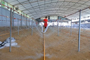 LUANNAN COUNTY, Çin - 19 Temmuz 2021: işçiler Çin 'deki bir balıkçı ağı işleme tesisinde yengeç ağlarını elle işliyorlar