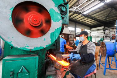 LUANNAN COUNTY, Çin - 24 Eylül 2021: işçiler yoğun bir şekilde Kuzey Çin 'deki bir donanım üretim fabrikasında üretim bandı üzerinde çalışıyorlar.