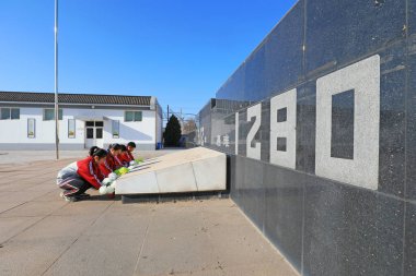 LUANNAN COUNTY, China - December 13, 2021: The students presented flowers to the monument, North China clipart