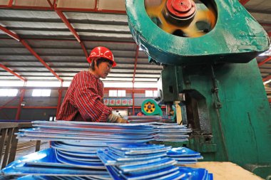 LUANNAN COUNTY, Çin - 22 Nisan 2021: işçiler Kuzey Çin 'deki bir kürek fabrikasında çelik kürek üretim hattı üzerinde sıkı çalışıyorlar