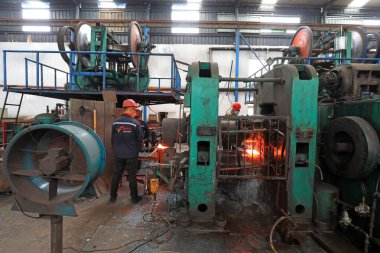 LUANNAN COUNTY, Çin - 22 Nisan 2021: işçiler Kuzey Çin 'deki bir kürek fabrikasında çelik kürek üretim hattı üzerinde sıkı çalışıyorlar