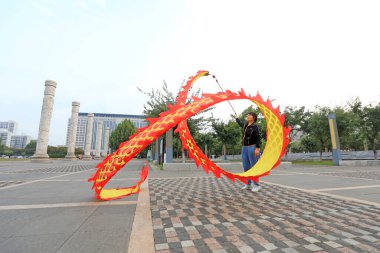 LUANNAN COUNTY, Çin - 1 Ekim 2021: Bir kadın spor yapmak için bir parkta kurdele sallıyor, Kuzey Çin