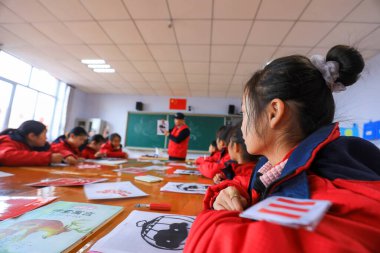 LUANNAN COUNTY, Çin - 10 Aralık 2021: İlkokul öğrencileri Çin 'deki öğretmenlerin rehberliğinde geleneksel kağıt kesme sanatını öğrenirler.