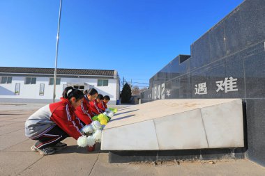 LUANNAN COUNTY, China - December 13, 2021: The students presented flowers to the monument, North China clipart