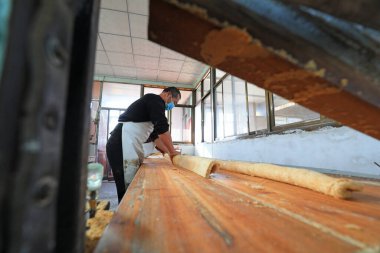 LUANNAN COUNTY, Çin - 19 Ocak 2022: İşçiler Kuzey Çin 'deki bir atölyede geleneksel Çin gevreği şekeri işliyorlar