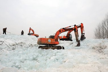 LUANNAN COUNTY, Çin - 21 Ocak 2022: çiftçiler Kuzey Çin 'deki buz küplerini ayırmak için kazıcıları kullanıyorlar