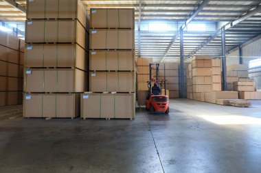 LUANNAN COUNTY, Çin - 26 Şubat 2022: İşçiler forkliftleri Kuzey Çin 'deki fabrikada yoğunluk tahtası ürünlerini taşımak için kullanıyorlar